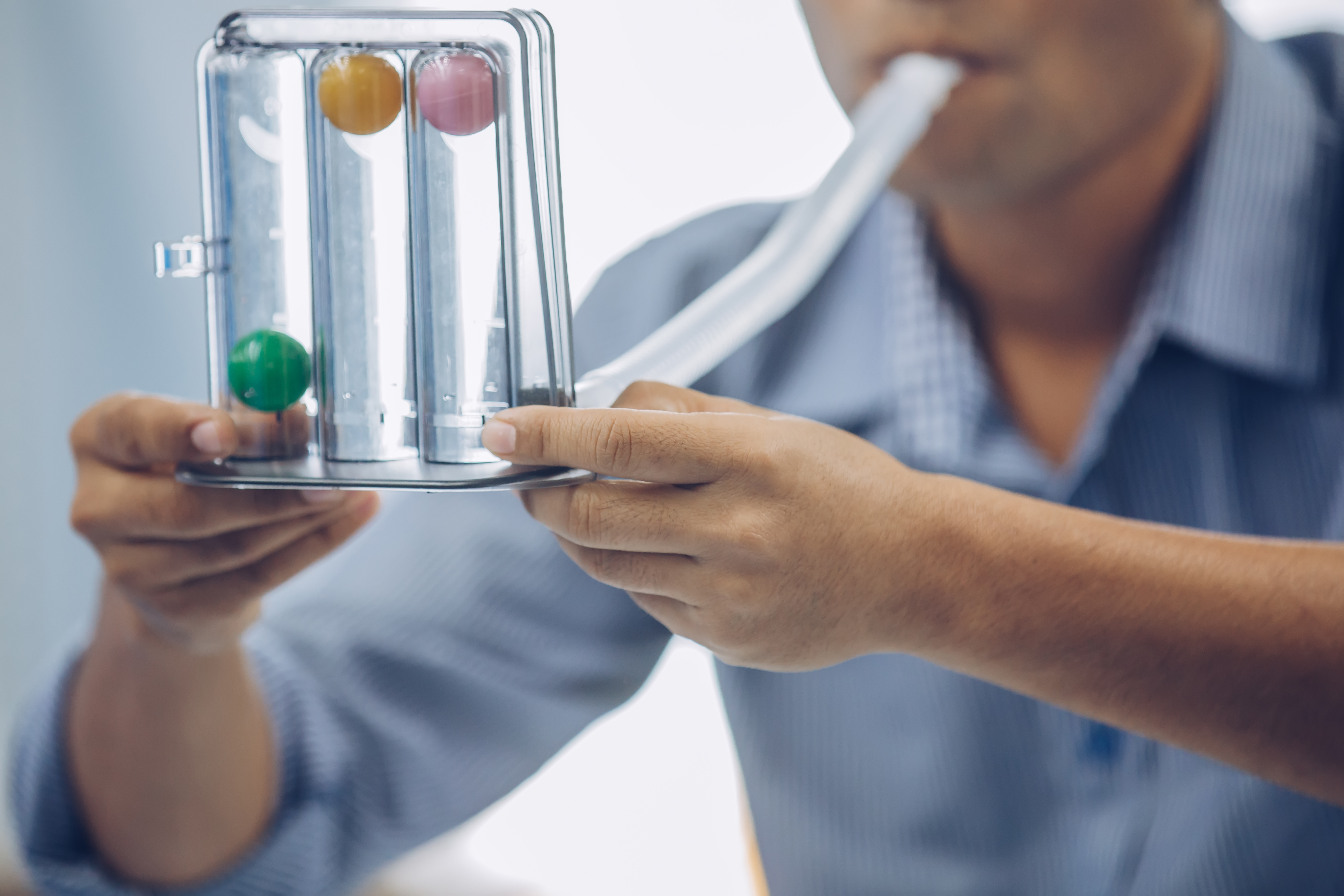 A man uses a device for a breathing test. 